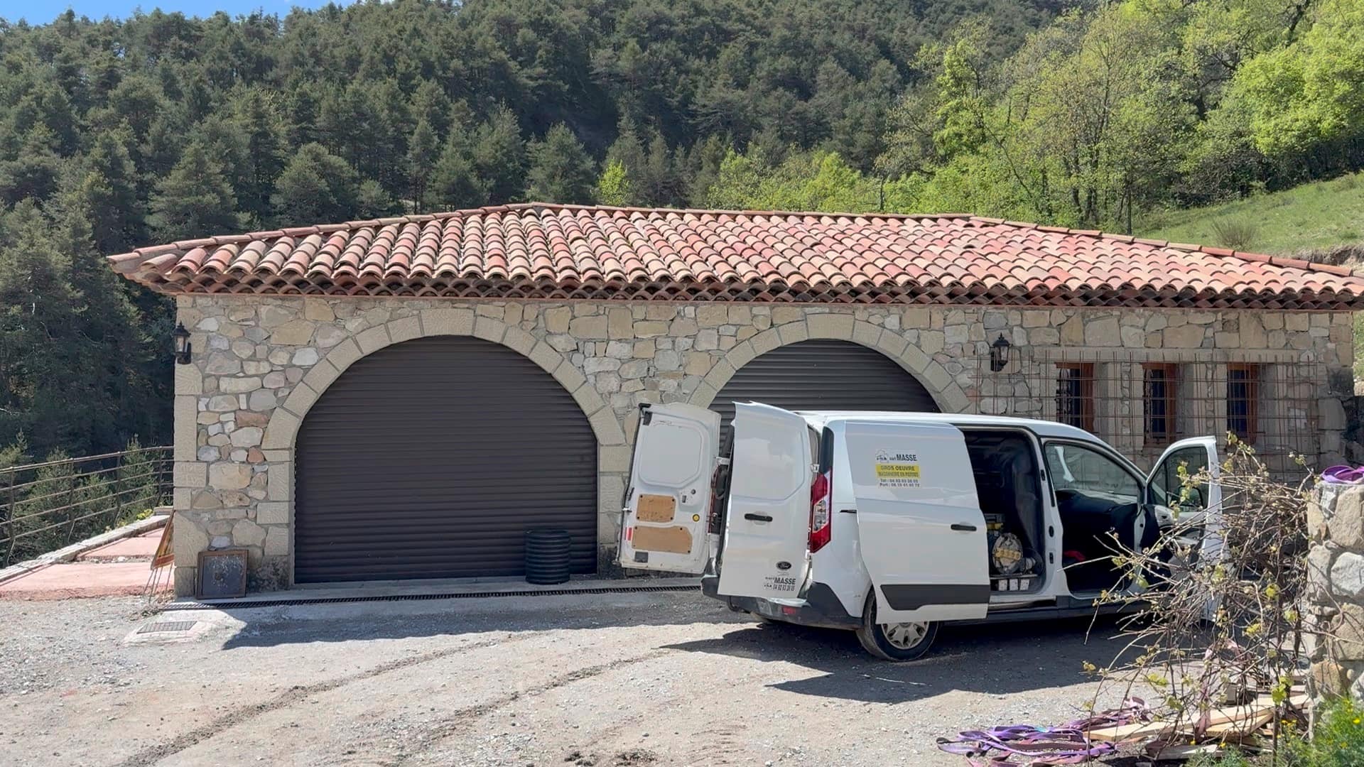 Double garage with dressed stone arches and a canal tile roof.
