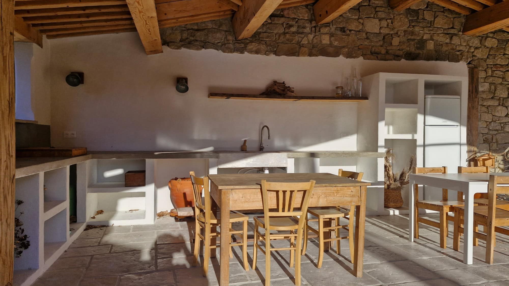 Room under an exposed timber frame, stone walls and stone flooring.